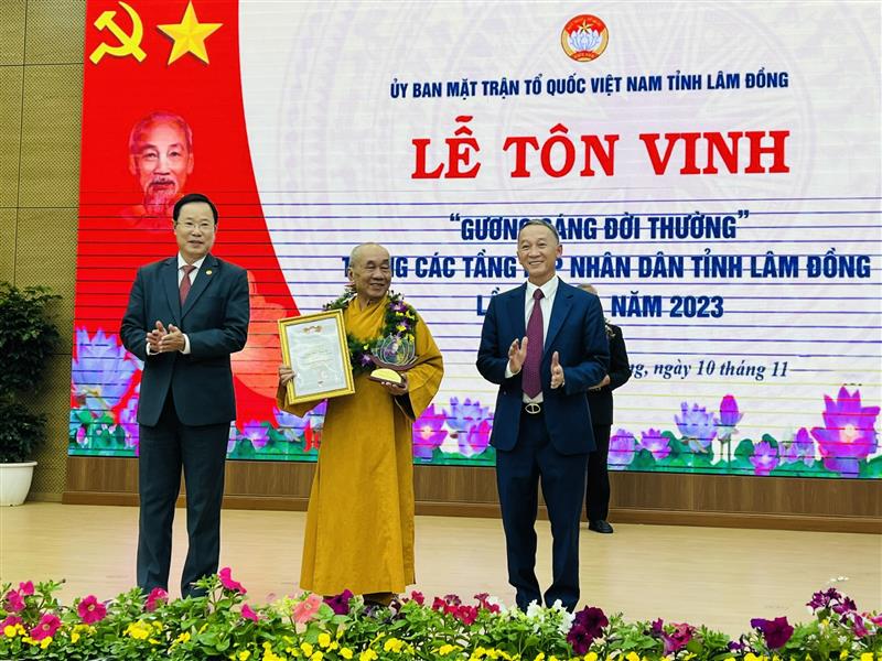 Chủ tịch UBND tỉnh Trần Văn Hiệp và Chủ tịch Ủy ban MTTQ Việt Nam tỉnh Phạm Triều tặng hoa, biểu trưng tôn vinh gương sáng đời thường.