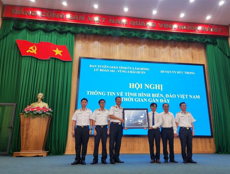 Thượng tá Trần Trung Dũng - Phó Chính ủy Lữ đoàn 162 - Vùng 4 Hải quân tặng ảnh lưu niệm về biển, đảo của Tổ quốc cho huyện huyện Đức Trọng.