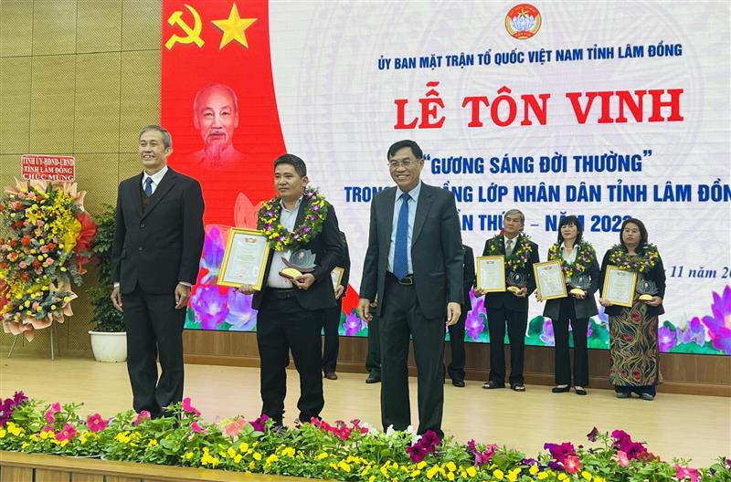 Đồng chí Võ Văn Thiện - Trưởng Ban Công tác phía Nam - Ủy ban Trung ương MTTQ Việt Nam và Phó Chủ tịch UBND tỉnh Lâm Đồng Võ Ngọc Hiệp trao tặng biểu trưng và hoa tôn vinh gương sáng