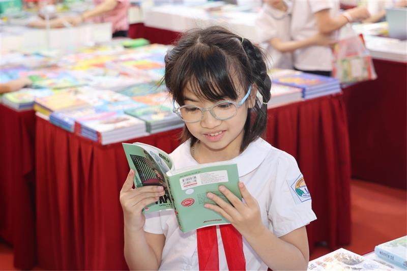 Một bạn đọc nhỏ tuổi tại Lễ khai mạc Ngày Sách và Văn hóa đọc Việt Nam lần thứ Ba, năm 2024.