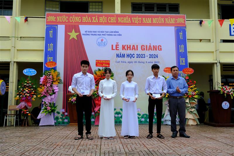 Đồng chí Trần Quốc Huy - Huyện ủy viên, Bí thư Đảng ủy xã Gia Viễn trao quà cho học sinh.